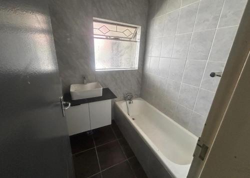 ein Badezimmer mit Badewanne und Waschbecken in der Unterkunft Madlabeezy in Kempton Park