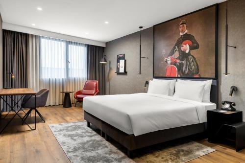 a hotel room with a bed and a painting on the wall at Radisson RED Izmir Point Bornova in İzmir