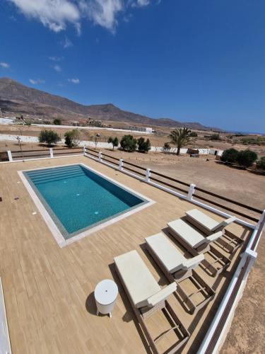 a swimming pool with chaise lounge chairs and a swimming pool at Casa Abuela Serapia in Tuineje