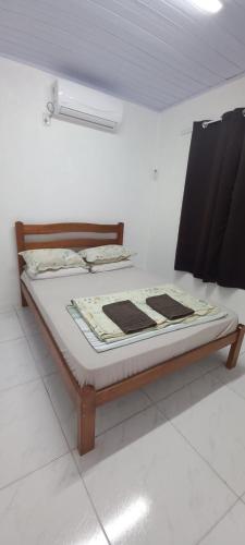 a bed sitting in a room with at Pousada Germânia em Paraíso do Sul RS in Paraíso do Sul