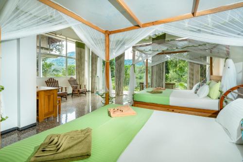 a bedroom with two beds and a living room at Evergreen Villa - Sinharaja in Deniyaya