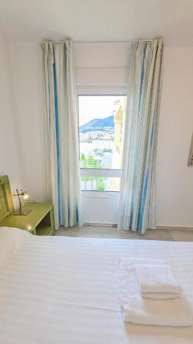 a bedroom with a bed and a large window at Casinomar Apartments Pool, Garden & Private Terrace in Benalmádena