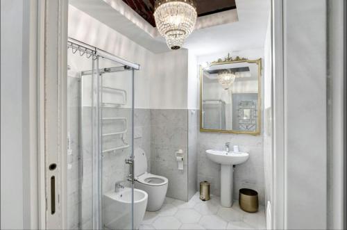 a white bathroom with a toilet and a sink at Seafront, Large Studio on the Beach with AC and WiFi in Pietra Ligure