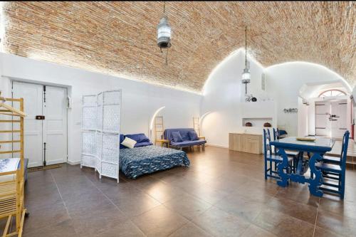 a living room with a bed and a table at Seafront, Large Studio on the Beach with AC and WiFi in Pietra Ligure