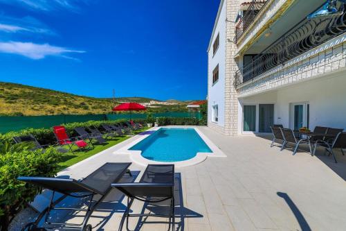 a patio with chairs and a swimming pool at Villa Olivia Trogir in Trogir