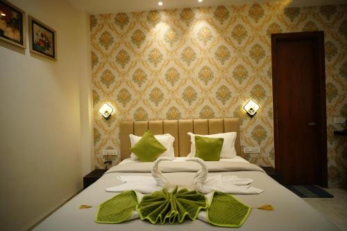 a bedroom with a bed with white sheets and green pillows at The Leaf Farm in Ludhiana