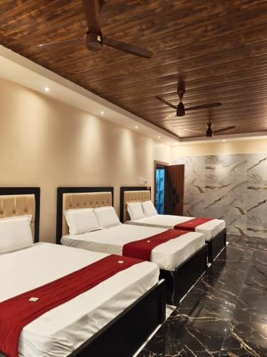 a bedroom with two beds and a stone wall at RCH Home Stay in Rāmeswaram