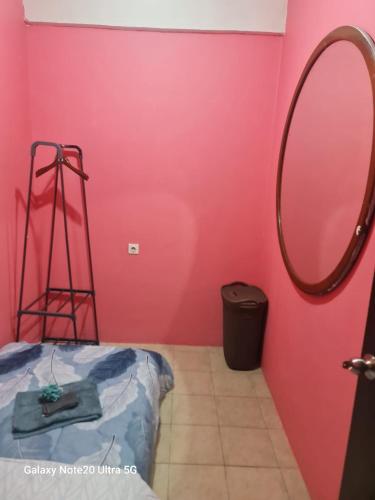 a bathroom with a pink wall and a mirror at Mountain View at The Edge in Cimindi-hilir