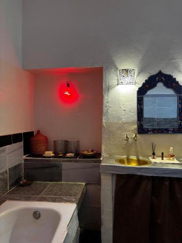 a bathroom with a tub and a sink with a red light at 34 Degrés Sud in Mirleft