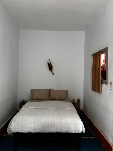 a white bedroom with a bed in a room at 34 Degrés Sud in Mirleft