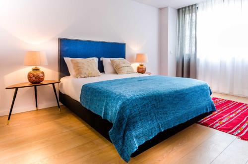 a bedroom with a large bed with a blue blanket at LSA Liberdade by Numa in Lisbon