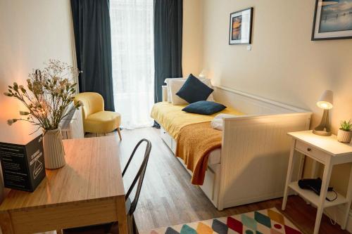 ein kleines Schlafzimmer mit einem Bett, einem Tisch und einem Schreibtisch in der Unterkunft 32 Bondgate Without in Alnwick