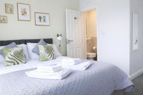 a white bed with towels on top of it at The Milford Arms in Hounslow