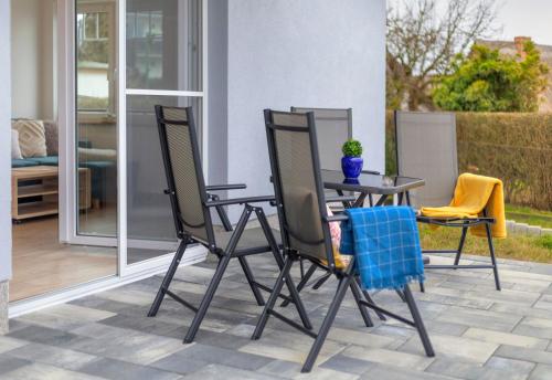 a patio with a table and chairs on a patio at Haus Achterwasserblick 1 in Loddin