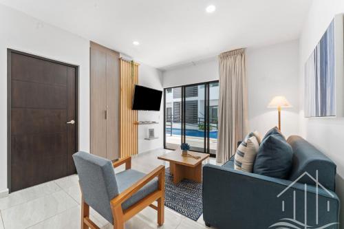 a living room with a couch and a chair and a television at New-Promo-2 Queen Beds-Near Beach-Poolside-Sleep 6 in Mazatlán