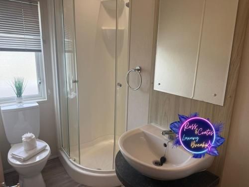 a bathroom with a sink and a shower and a sign at Goaty Lodge - 2 The Green in Tattershall