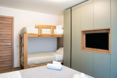 a bedroom with two bunk beds and a tv at El Surcinel – Alpine Design Home in Ballabio