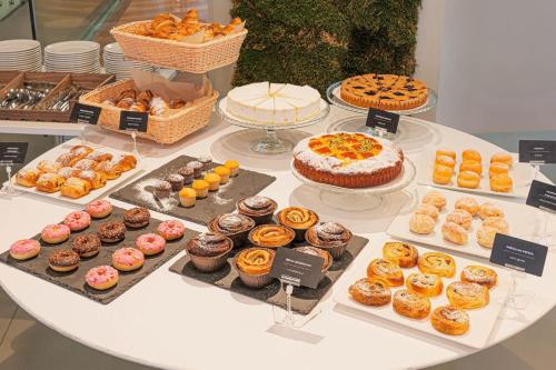a table with many different types of donuts and cakes at B&B HOTEL Fabriano Janus in Fabriano