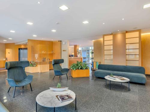 a living room with a couch and chairs and tables at B&B HOTEL Bergamo Executive in San Paolo D'Argon