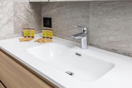 a bathroom sink with two yellow glasses on it at La Strencia in Villa di Tirano