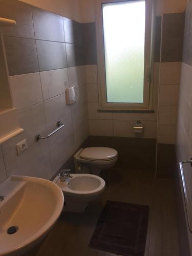 a bathroom with a sink and a toilet and a window at Belvedere Residence in Zungri