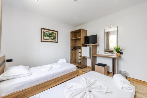a hotel room with two beds and a desk at Bliss by PikHost in Gjirokastër