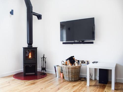 a living room with a wood stove and a tv at Rubys Cottage in Crieff