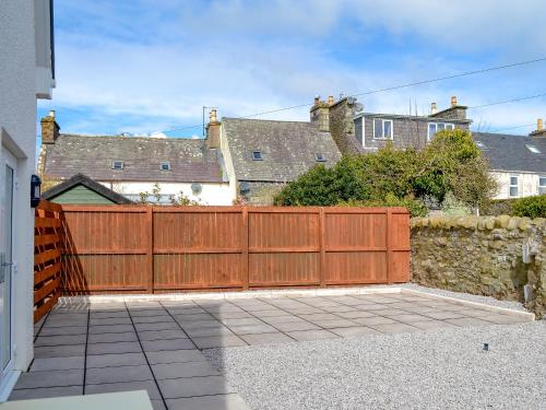 a wooden fence in front of a house at Crofthouse - Uk43405 in Wigtown