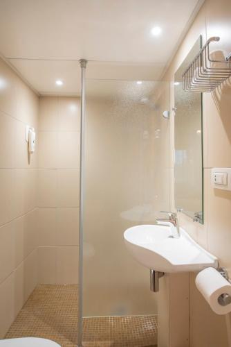 a bathroom with a sink and a shower at The Originals Access Hôtel Bordeaux Aéroport in Mérignac