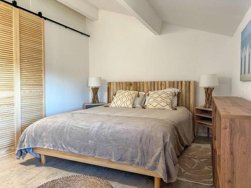 a bedroom with a large bed and two lamps at Le Mazet au Lavandou in Le Lavandou