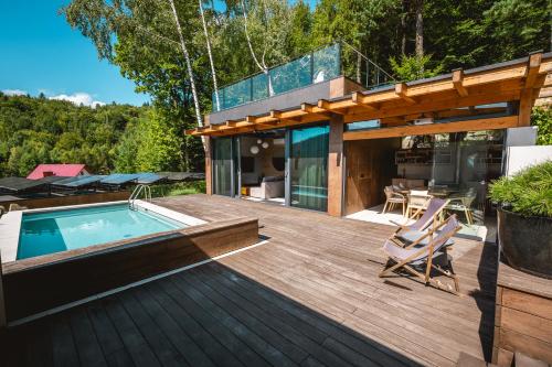 a deck with a swimming pool and a house at Niebo Beskidu in Brenna