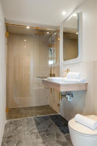 a bathroom with a shower and a toilet and a sink at Comfort Hotel Park in Trondheim