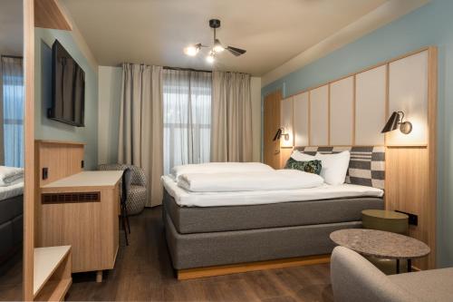 a small hotel room with a bed and a desk at Comfort Hotel Park in Trondheim