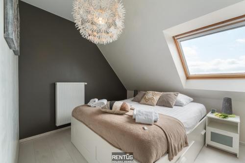 a bedroom with a bed and a chandelier at Maison Beluga - spacious apartment in Westende in Middelkerke