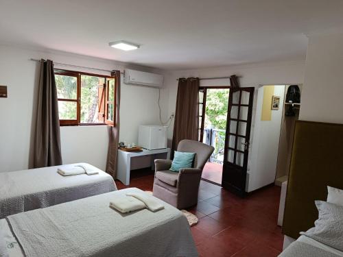a hotel room with two beds and a chair at My Place Boutique Hotel in Puerto Iguazú