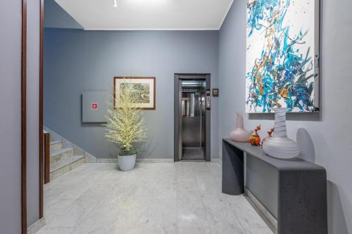 a hallway with vases and a painting on the wall at Welcome Foresteria Lombarda in Milan