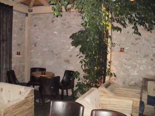 a room with chairs and a table and a wall at Aktaion Hotel in Monemvasia