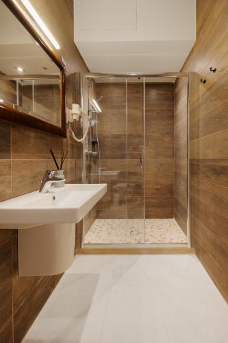 a bathroom with a sink and a shower at Nelsonhaus -Boutique Guesthouse in Cospicua