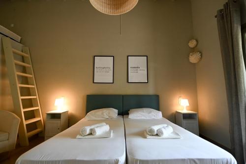 two beds in a room with two towels on them at Aggelos Grand in Koukounaries
