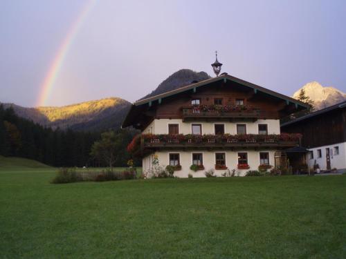 a large house with a rainbow in the background at Edthof in Lungötz