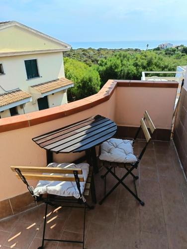 a pair of chairs and a table on a balcony at Il Mascone in Stintino