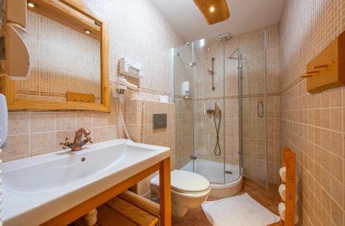 a bathroom with a sink and a toilet and a shower at Pinius by Hotel Pieris in Pribylina