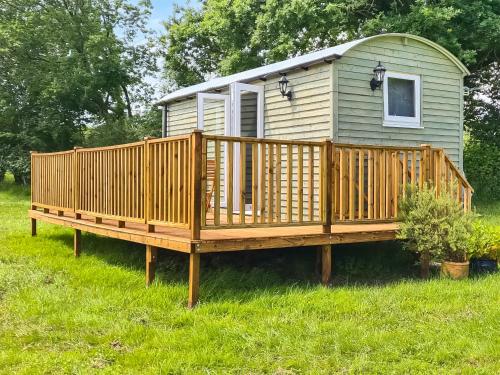 a large deck with a house in the grass at Badgers - Uk46750 in Herstmonceux