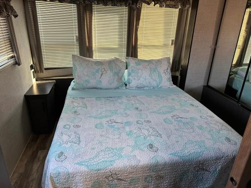 a bed in an rv with a comforter on it at Big Pine Key RV Park in Big Pine Key
