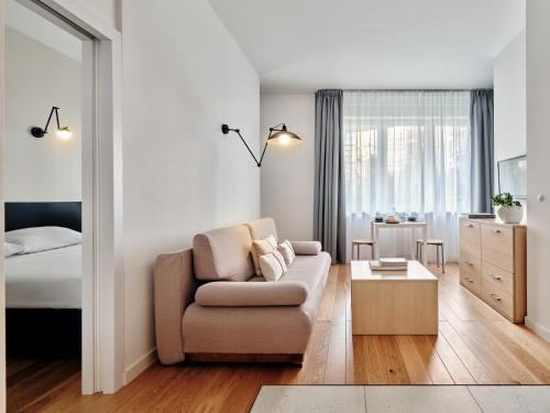 a living room with a couch and a bedroom at Apartamenty Media Park in Warsaw