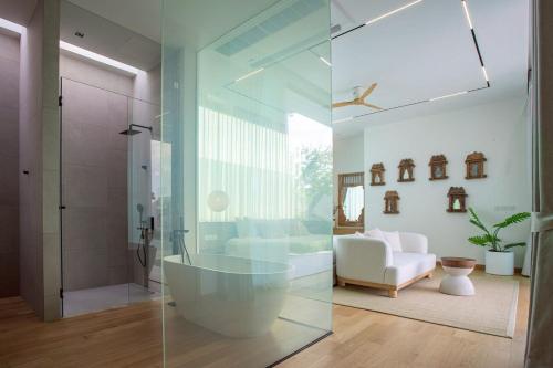 a bathroom with a tub and a glass shower at OASIS Luxury Private Villa in Ban Phru Champa