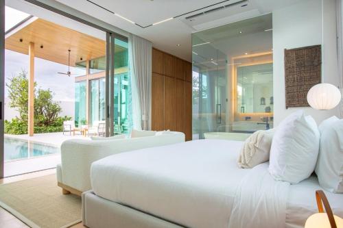 a bedroom with a white bed and a pool at OASIS Luxury Private Villa in Ban Phru Champa