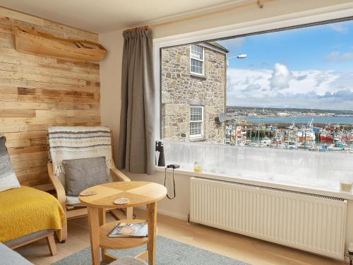 a bedroom with a large window with a view of the water at Old Quay in Newlyn
