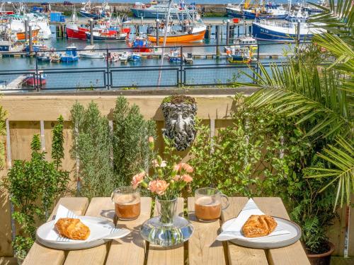 a table with two plates of food on top of a marina at Old Quay in Newlyn