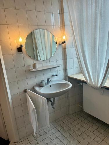 a bathroom with a sink and a mirror at Restaurant Rebea in Sulzburg